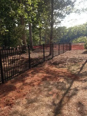 Black aluminum fence along a wooded lot — Timber Fencing, Monroe, NC