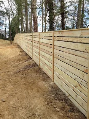 Long horizontal wood fence run on a sloped lot — Timber Fencing, Monroe, NC