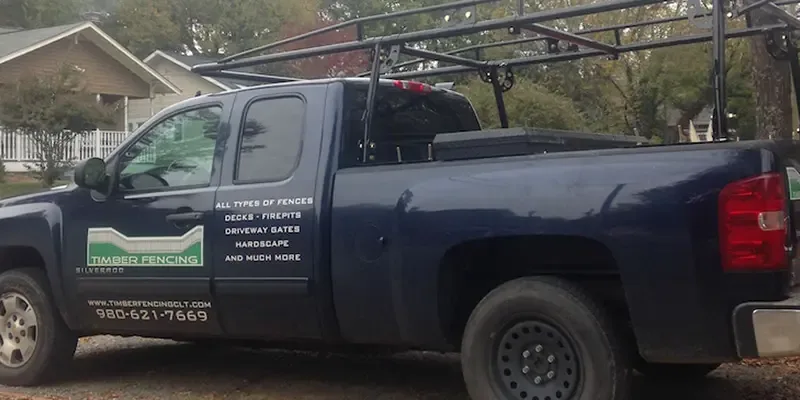Timber Fencing work truck with ladder rack, lettered with the company logo and phone number