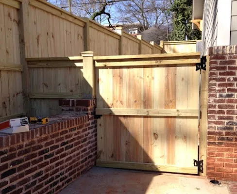 Wood privacy fence and gate beside a brick wall — Timber Fencing, Monroe, NC